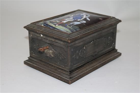 An early 19th century Limoges style enamel plaque set in a later carved ebonised casket, 7in.